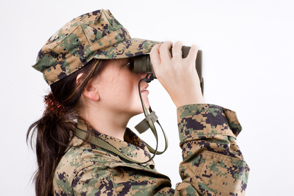 The attractive girl in a camouflage with a binoculars